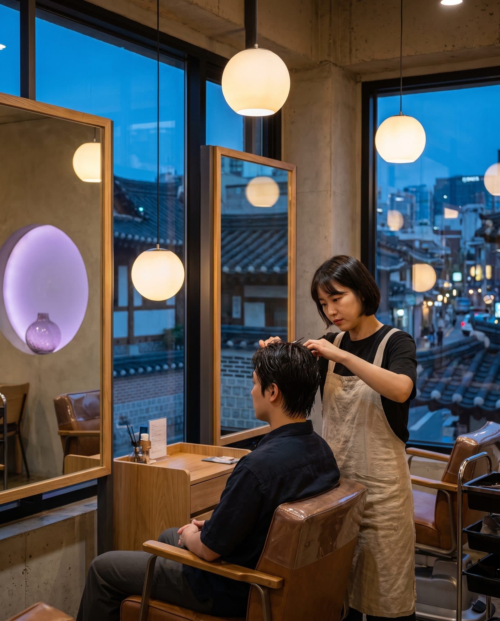 해 질 녘 한옥 지붕이 보이는 미용실에서 일하는 미용사